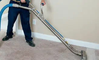 Professional operating a liquid removal machine on a carpeted floor in Fort Lauderdale, FL